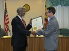 Dr. S. James Gates is honored by Governor O’Malley for his being named a recipient of the National Medal of Science.  John Ratliff, right, Director of Policy for the Governor, presented the citation this week on the Governor’s behalf.