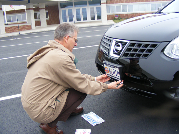Jennifer’s principal, Bill Carlson, adjusting the special Teacher of the Year license plate.